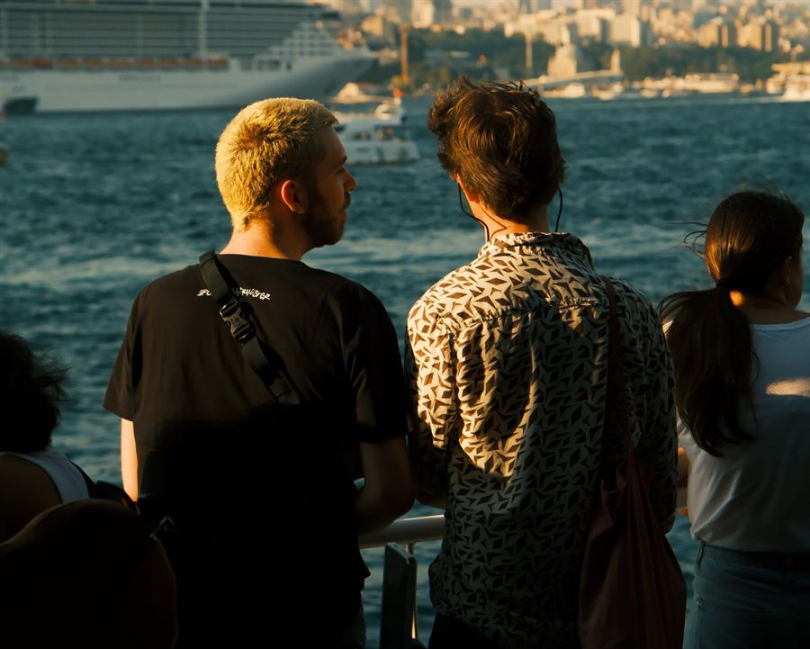 Friends at the rail of a ship admiring the view over the water