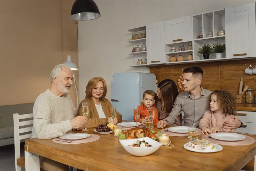 Grandparents, parents and children sharing a meal at a kitchen table