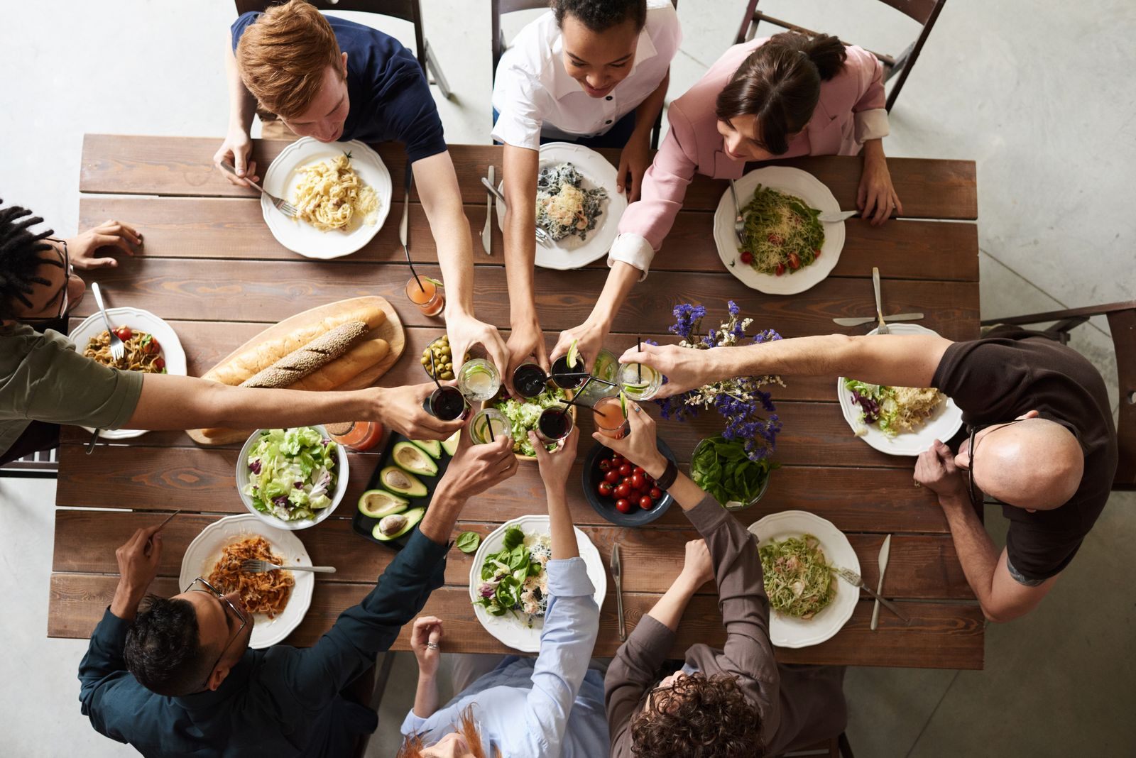 Overhead view of a big group sharing dishes around one long table, the dining challenge of a cruise for large groups